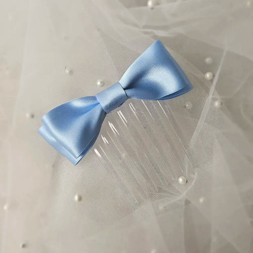 Blue satin ballet exam bow on a clear hair comb, designed for classical ballet examinations
