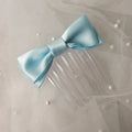 Light blue satin ballet exam bow on a clear hair comb, designed for classical ballet examinations