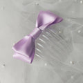 Lilac satin ballet exam bow on a clear hair comb, designed for classical ballet examinations