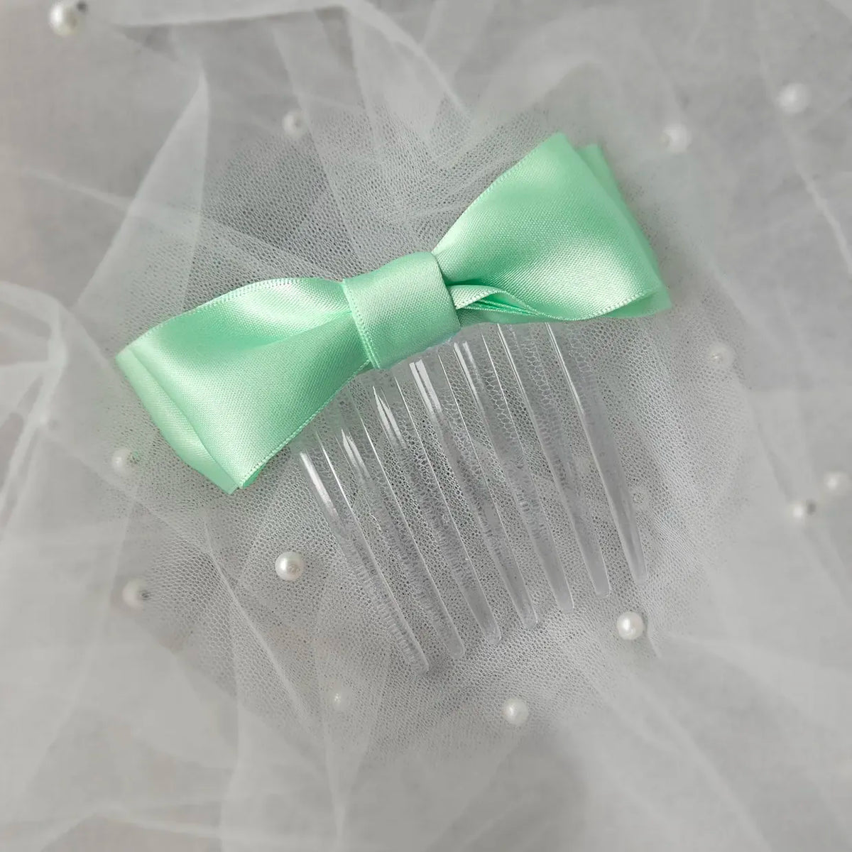 Mint satin ballet exam bow on a clear hair comb, designed for classical ballet examinations