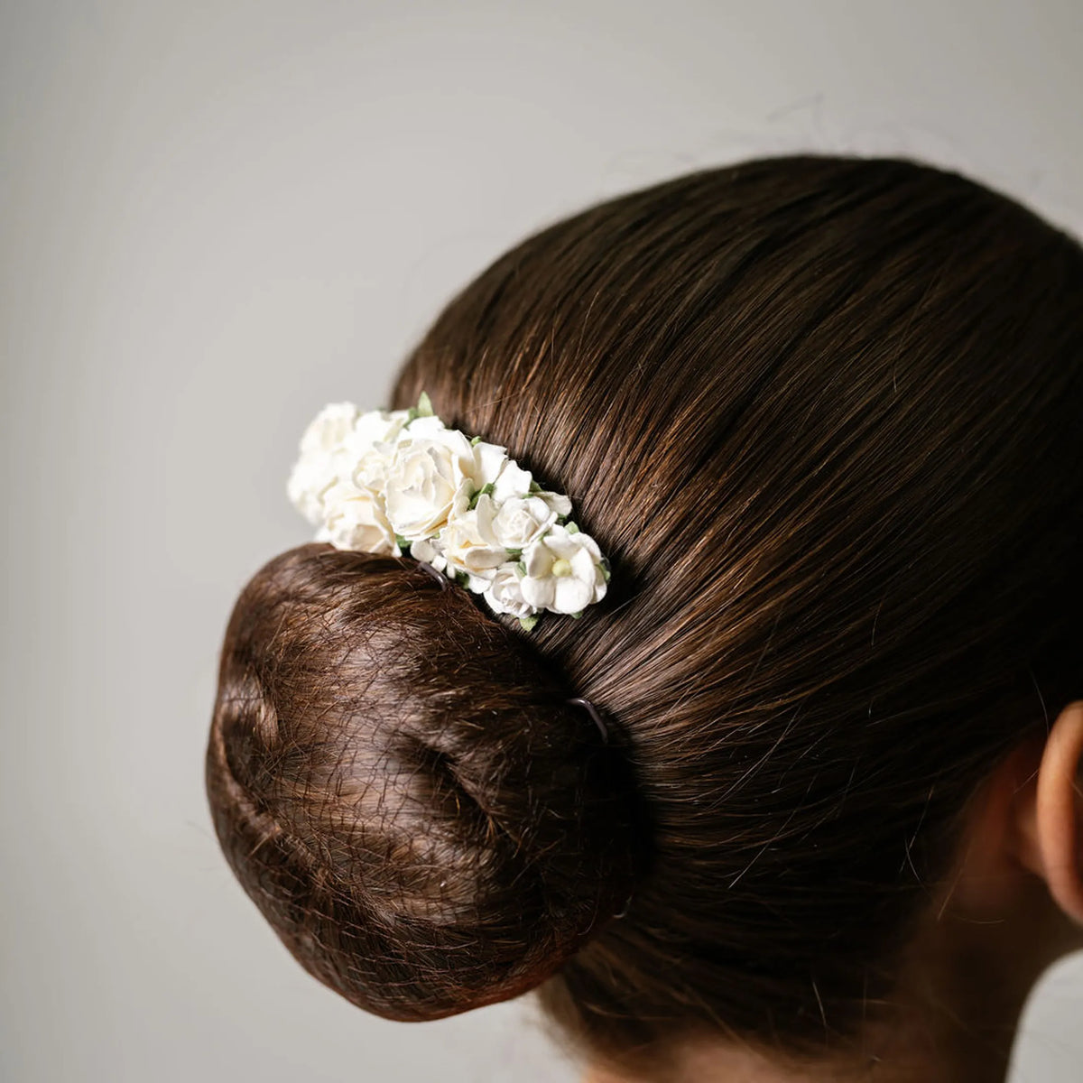 Ballet French twist clear hair comb with a white floral design on a bun