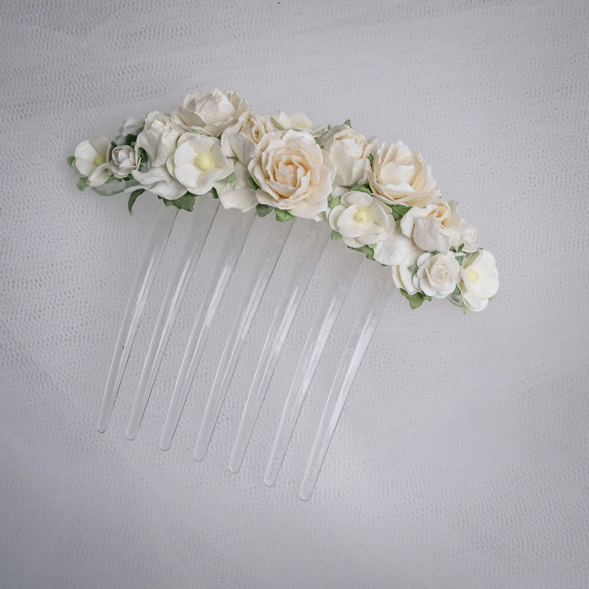 Ballet French twist clear hair comb with a white floral design on a white background