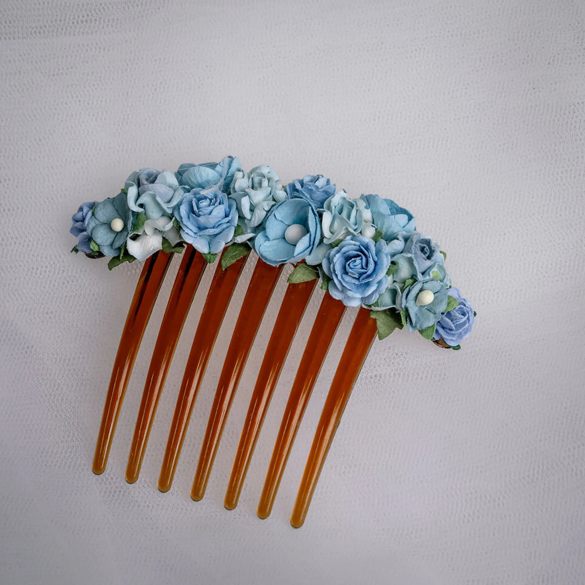 Ballet French twist brown hair comb with a light blue floral design on a white background