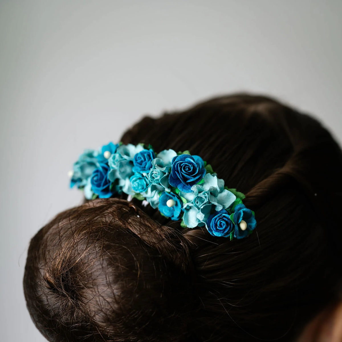Ballet French twist clear hair comb with blue and teal floral design on a bun