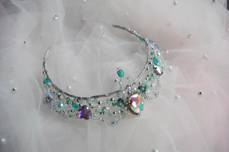 Decorative tiara with colorful gemstones on a soft white background