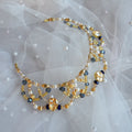 Beaded tiara with gold, blue, and white beads on a sheer fabric background